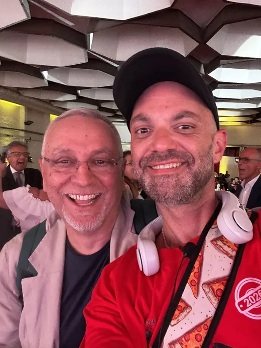 Patrick taking a selfie with a smiling attendee inside the Caputo Cup venue