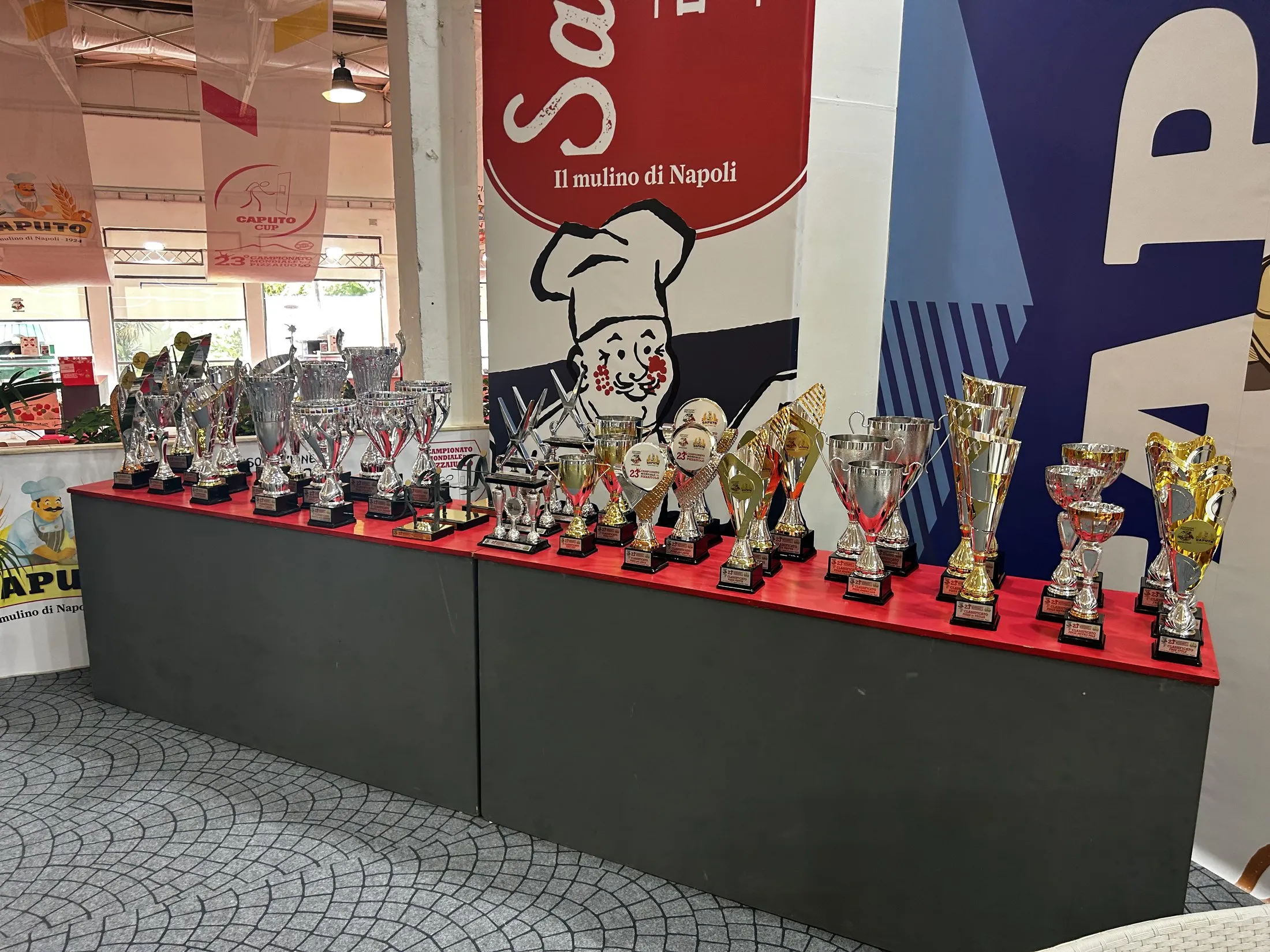 Rows of silver and gold trophies lined up for competitors at the Caputo Cup in Naples