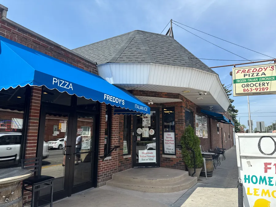 Freddy's Pizza storefront with its blue awnings on a sunny Cicero corner
