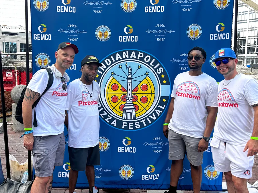 Four slice scouts posing at the Indianapolis Pizza Festival step-and-repeat backdrop