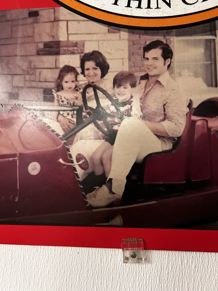 A framed family photo on Pat's wall: kids and parents on an antique fire truck