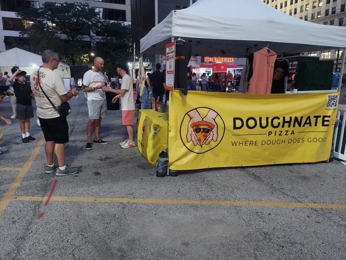 The Doughnate Pizza tent banner: "Where dough does good"