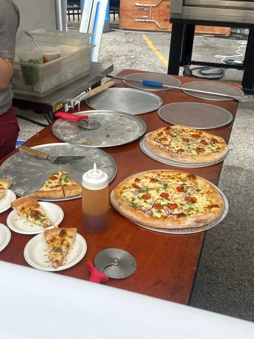 Fresh pies and cut tasting slices crowding a prep table at the fest