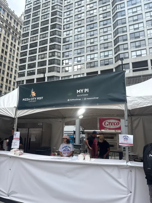 The My Pi booth tent at Pizza City Fest between downtown towers