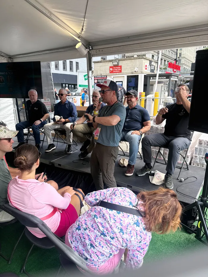 Pizza makers and fest-goers gathered around a panel talk under the tent
