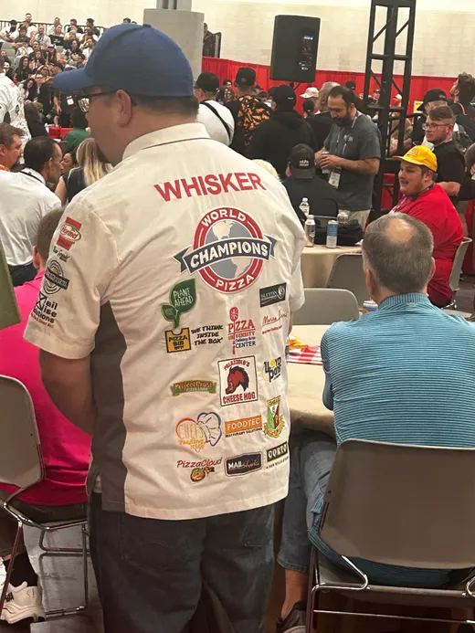 A competitor wearing a World Champions jersey covered in pizza competition patches