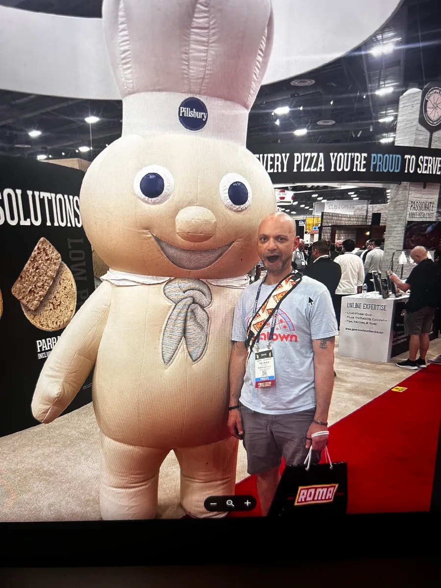 The Pillsbury Doughboy mascot working the red carpet at a Pizza Expo booth