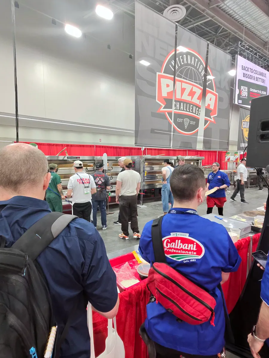 Crowd gathering under the Pizza Challenge stage banner at Pizza Expo