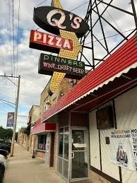 Q's Pizza vintage neon sign towering over the red-awning storefront in Hillside
