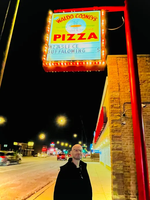Waldo Cooney's Pizza sign lit up over South Pulaski at night