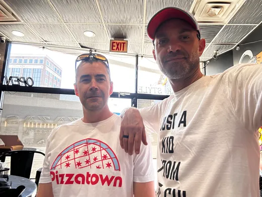 Two slice scouts in Pizzatown gear posing inside Zaza's Lakeview East shop